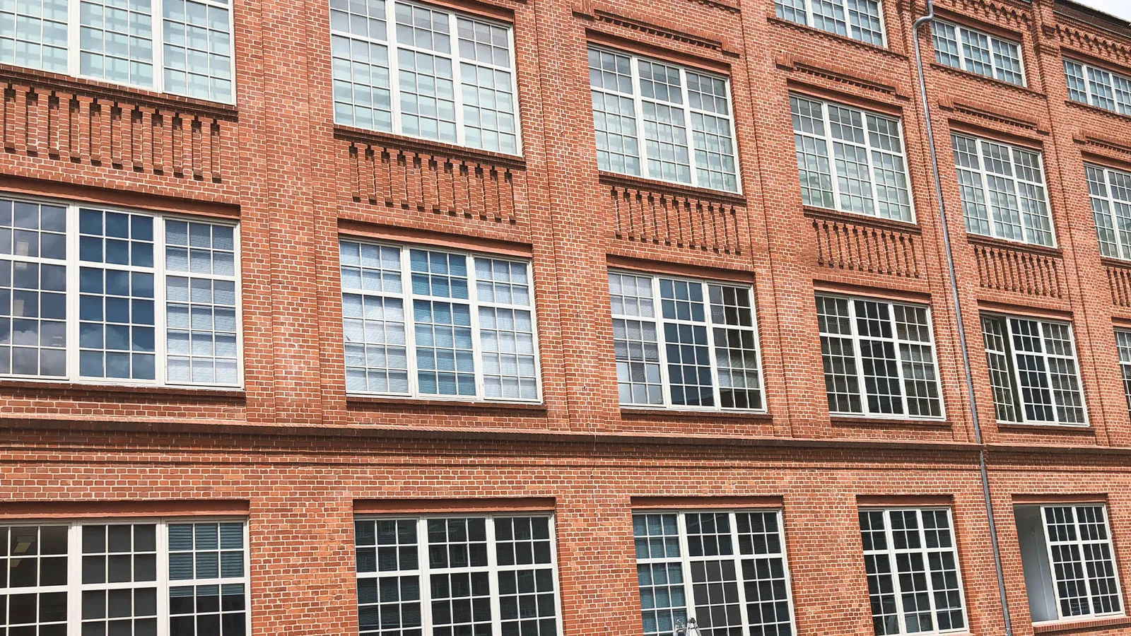 Historische Backsteinfassade mit großen Industriefenstern