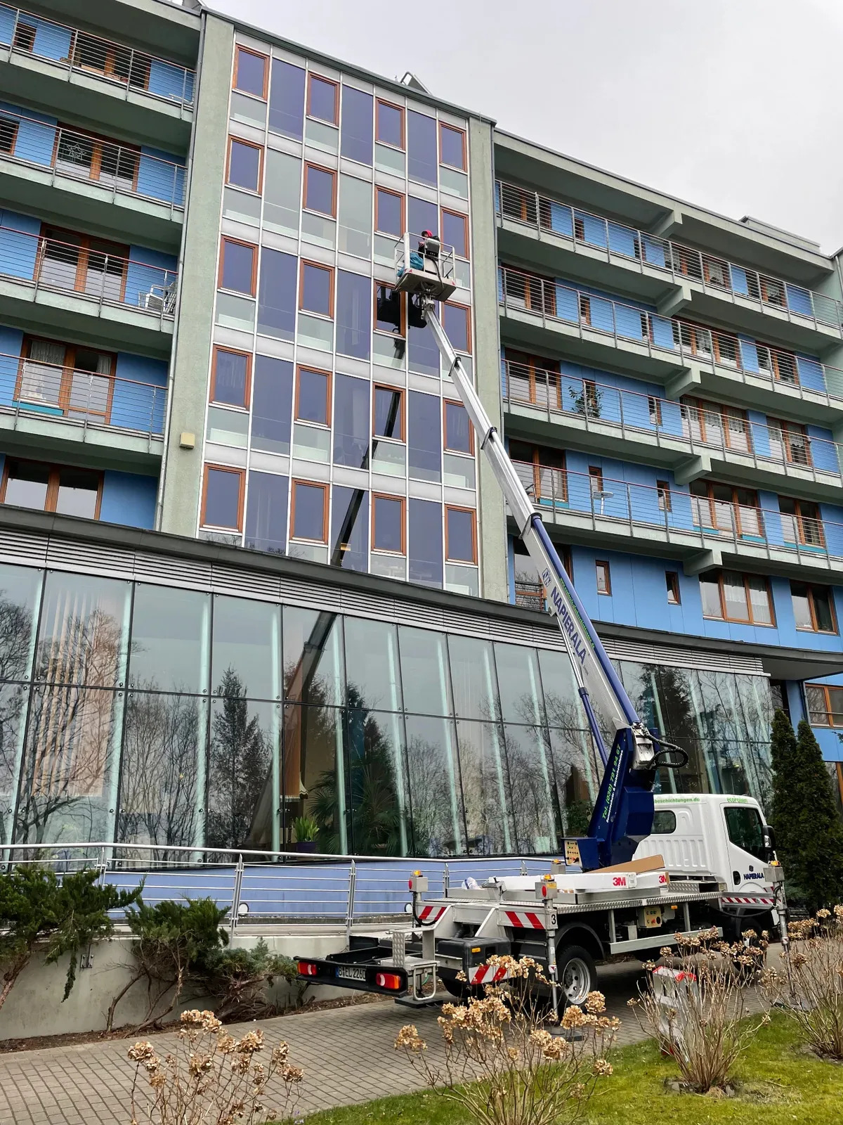 Folienmontage an einem mehrgeschossigen Hotelgebäude mit Arbeitsbühne